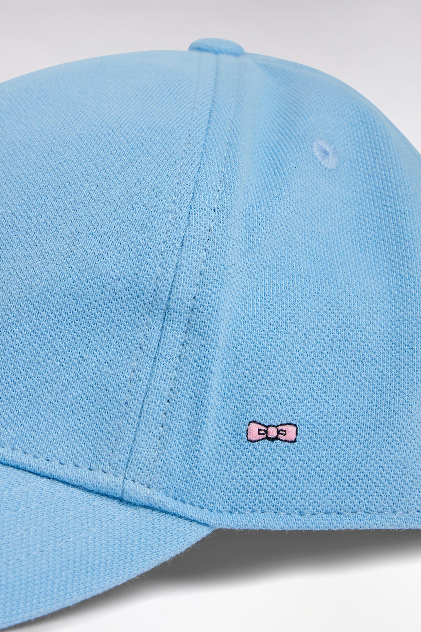 Sky blue cotton piqué cap with bow tie embroidery