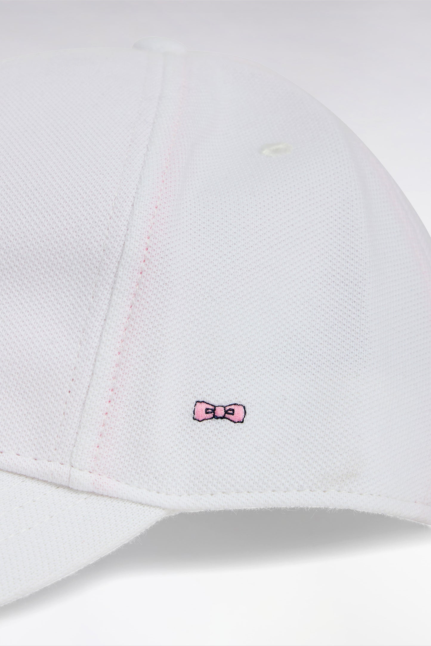 White cotton piqué cap with bow tie embroidery