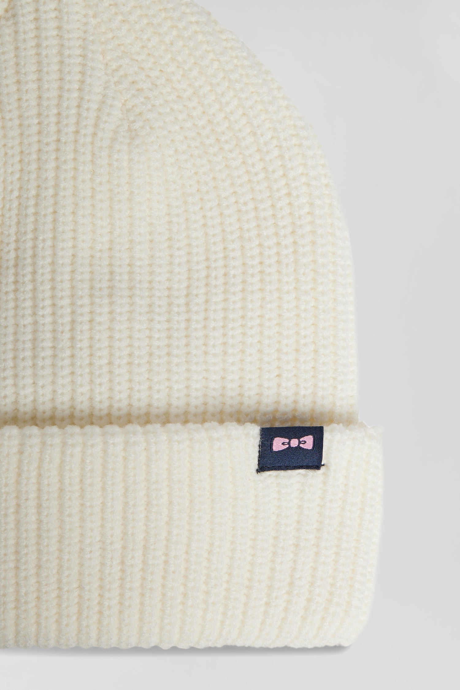 Ivory knitted beanie with bow tie embroidery