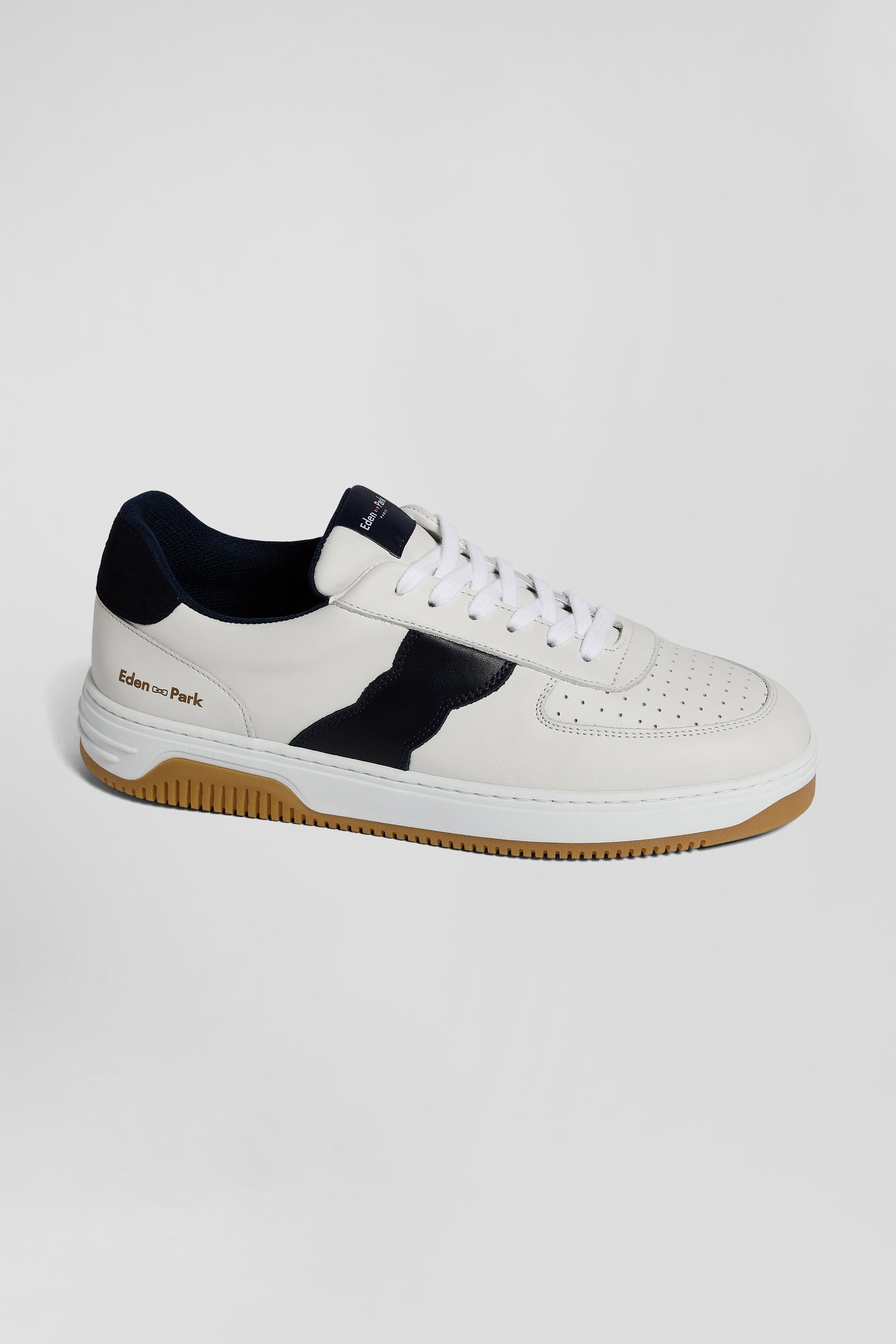 White low-top leather sneakers with navy blue cut-out