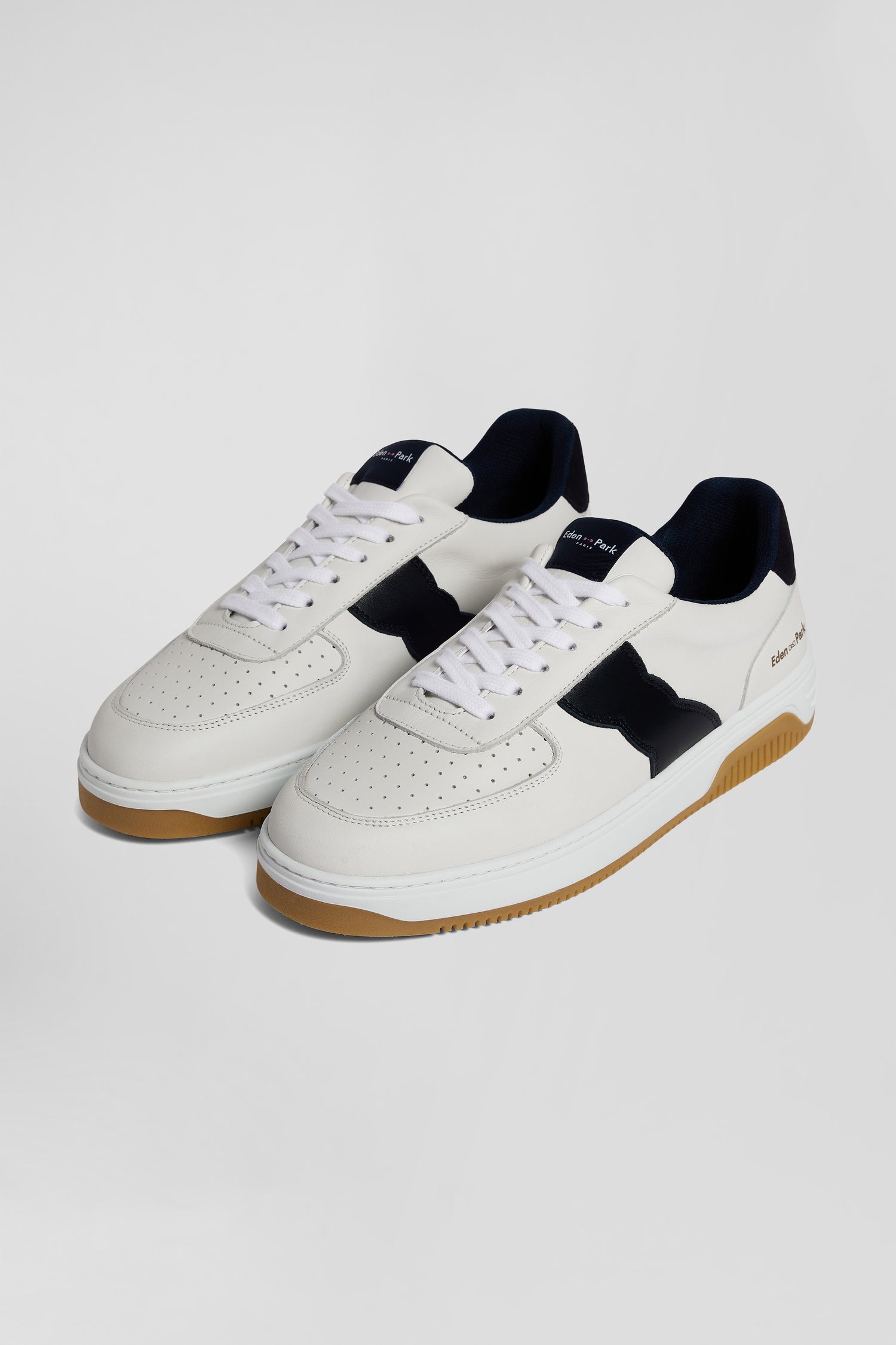 White low-top leather sneakers with navy blue cut-out